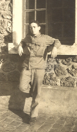 Serviceman standing outdoors in a military field uniform.