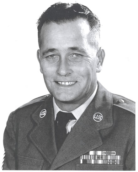Smiling Odell L. Huffman wearing glasses and a military uniform.