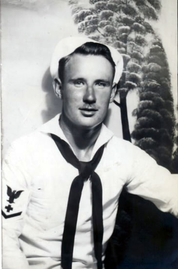 Serviceman wearing a U.S. Navy uniform in a formal portrait.