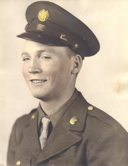 Smiling serviceman wearing a U.S. Army uniform and peaked cap.