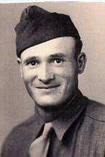 Smiling Omer Linenberger wearing a military uniform and garrison cap.