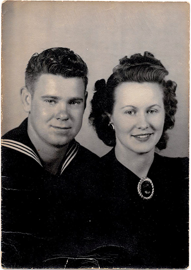 Sailor posing with a woman in a formal black-and-white portrait.