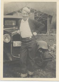 Otis Clevenger seated outdoors beside a vintage car.