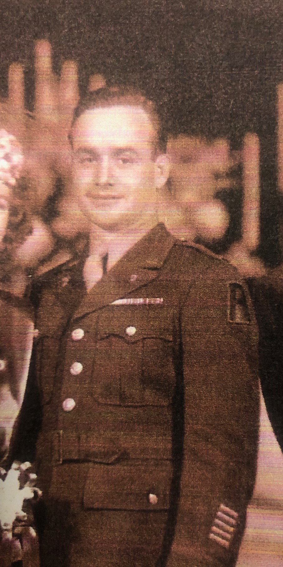 Serviceman wearing a U.S. Army uniform in a faded portrait.