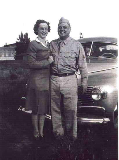 Ralph B. Parrott standing beside a woman and a car.