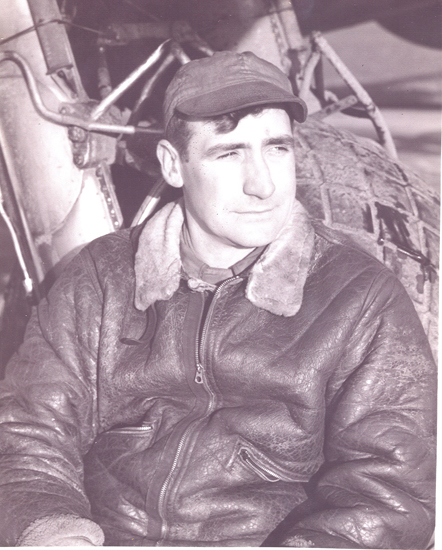 Military pilot wearing a leather flight jacket and cap.