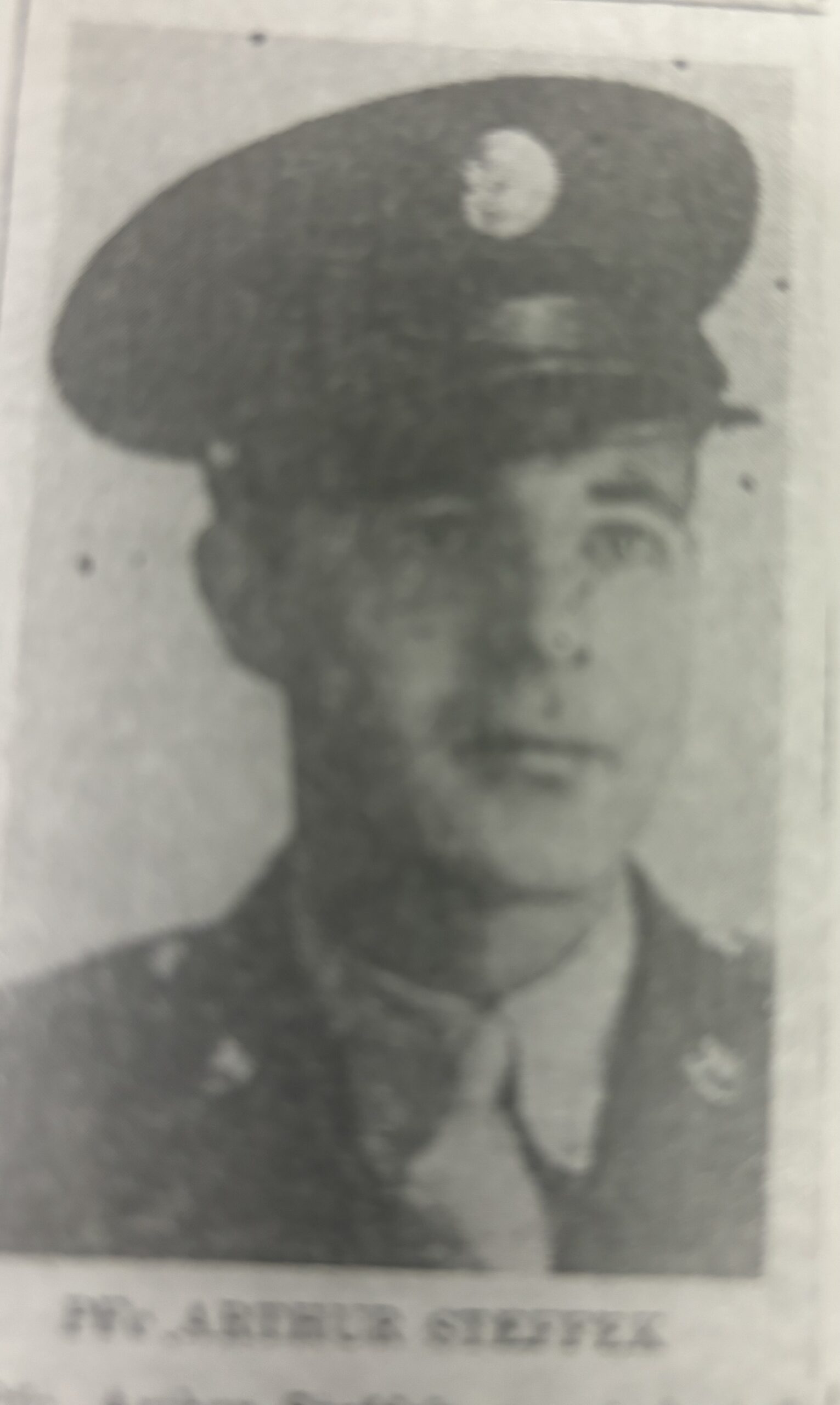 A black and white newspaper photo of a male military officer wearing uniform.