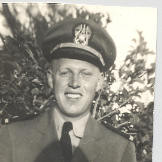 Older veteran wearing a military cap in an outdoor portrait.