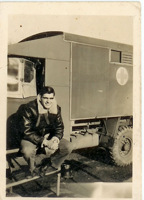 Serviceman seated outside a military trailer.