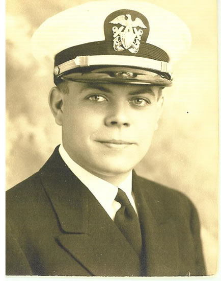 Naval officer wearing a white dress uniform and peaked cap.
