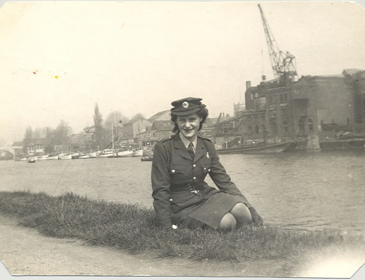 Violet Vera Phillips standing in uniform near a harbor.