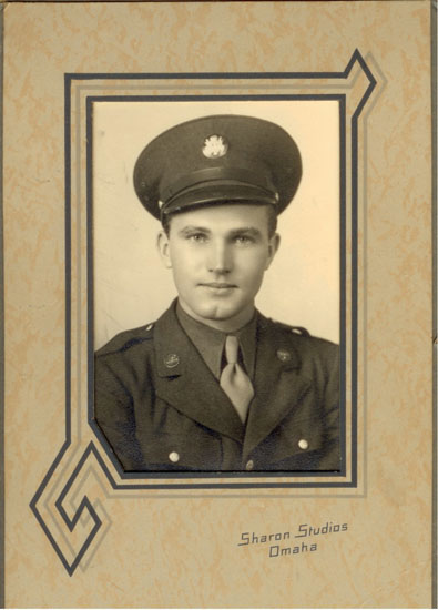 Framed portrait of a serviceman wearing a military uniform and peaked cap.