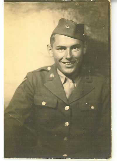 Smiling serviceman wearing a military uniform and garrison cap.