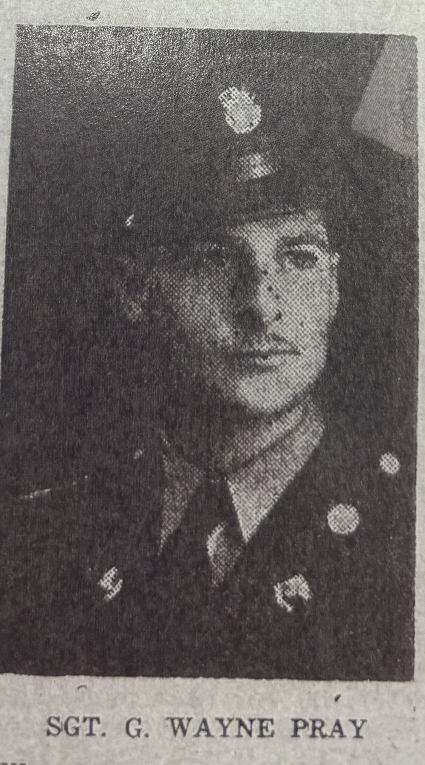 Young serviceman wearing a military uniform in a dark portrait.