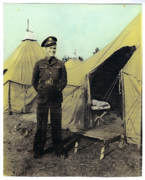 Walter Douglas Wall Sr. standing beside military tents in uniform.