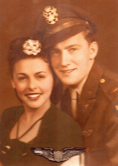 Smiling serviceman posing with a woman in a formal portrait.