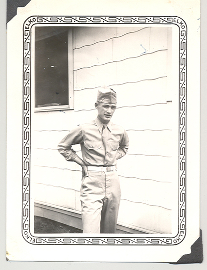 William F. Weber standing outside a house in military uniform.