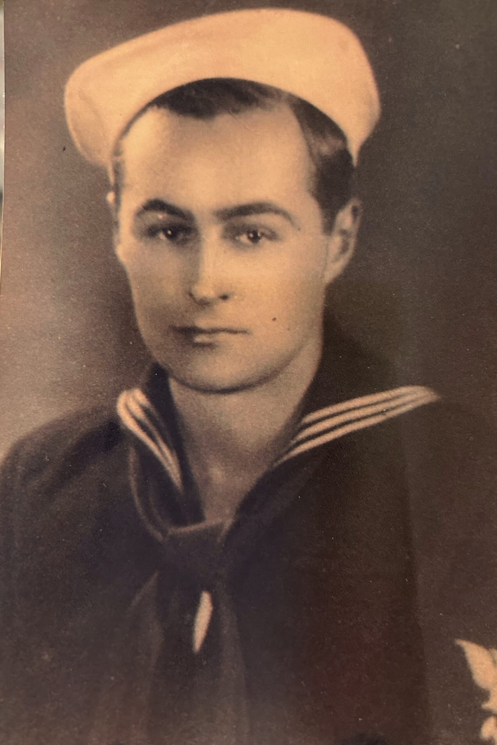 Young sailor wearing a dark naval uniform in a formal portrait.