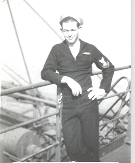 Sailor standing outdoors in a dark naval uniform.