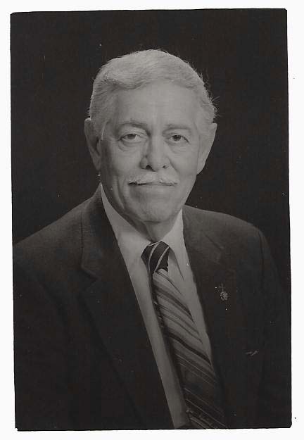 Older man wearing a suit in a formal portrait.