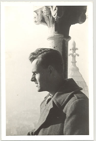 Serviceman shown in profile beside a building column.