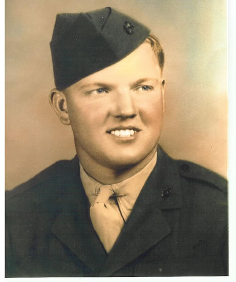 Smiling serviceman wearing a military uniform and tilted garrison cap.