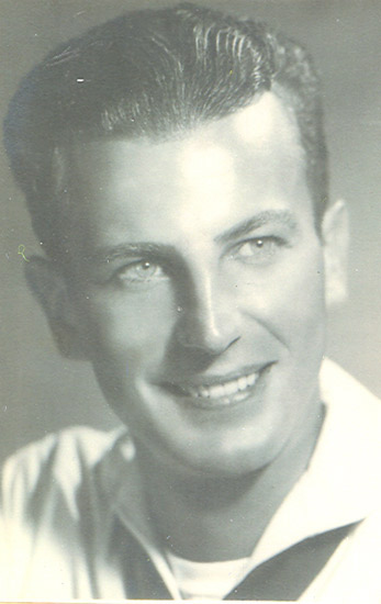 A man smiling at the camera, appearing relaxed and confident. He has short, neatly combed hair, a friendly expression, and is wearing what seems to be a light shirt.