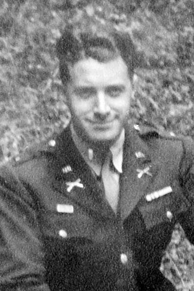 This is an old black-and-white photo of a man in uniform. He appears to be standing outside. The man has short hair and seems to be posing for the photograph.