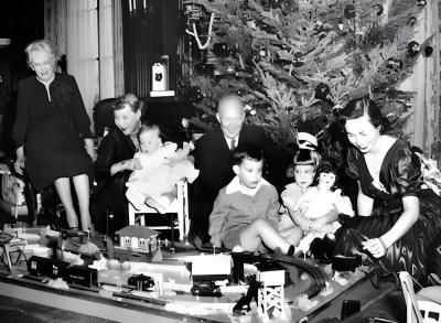 Dwight D. Eisenhower and his family gather around a model train beneath a Christmas tree.