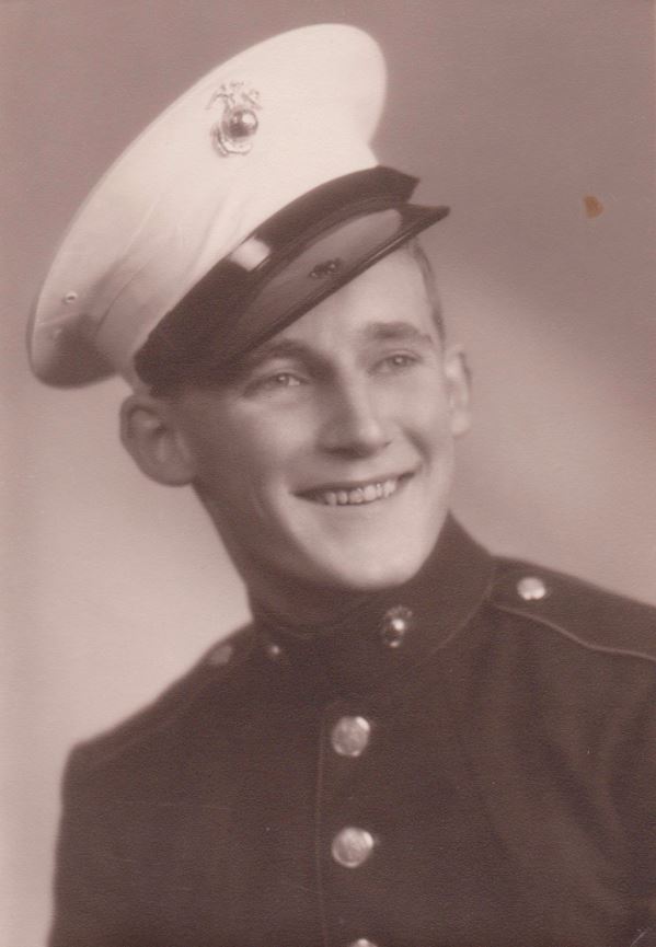 Smiling serviceman wearing a tilted military cap.