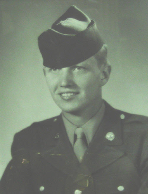 Young serviceman wearing a dark military cap and uniform.