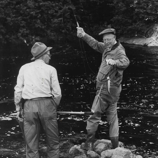 Dwight D. Eisenhower fly-fishing while another man watches nearby.