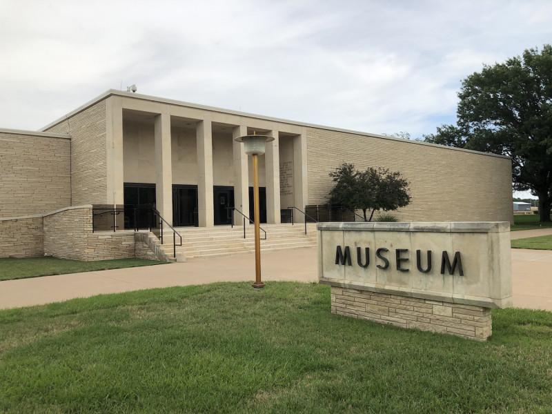 Exterior of the Eisenhower Presidential Library and Museum, with a museum sign in the foreground.