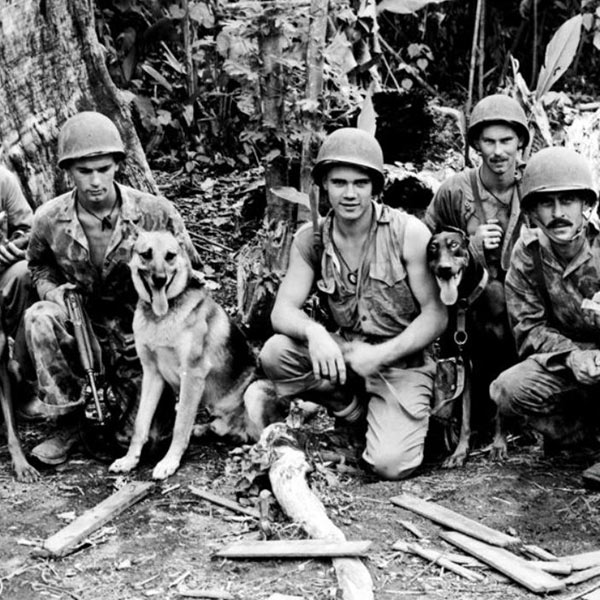 World War II soldiers gathered with a military working dog.