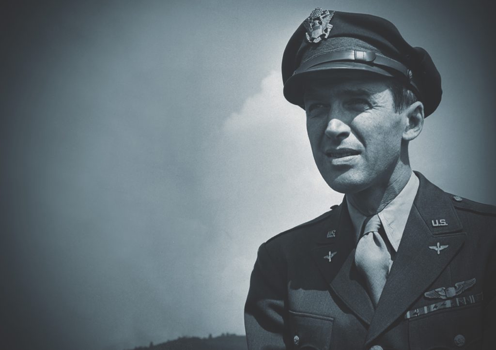 Military pilot wearing a flight cap in an outdoor portrait.