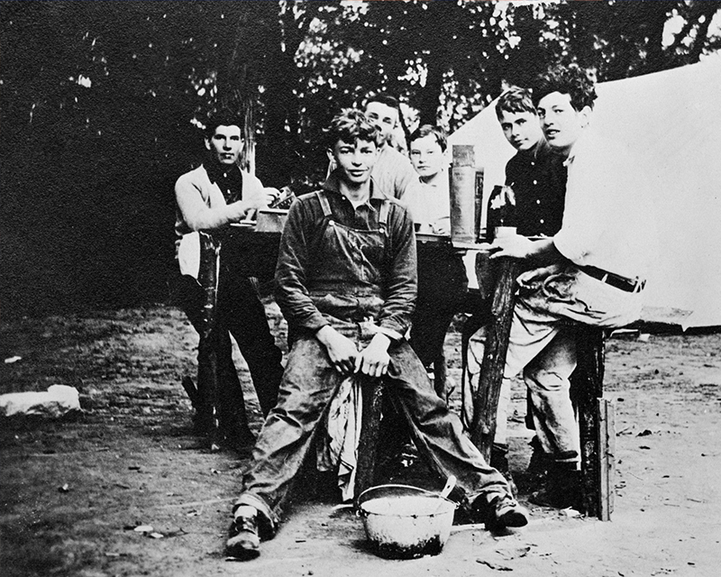 Young Dwight D. Eisenhower poses outdoors with a group of men.